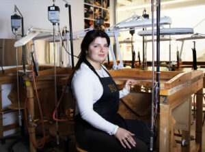 BAJ student at jewellery workbench wearing apron
